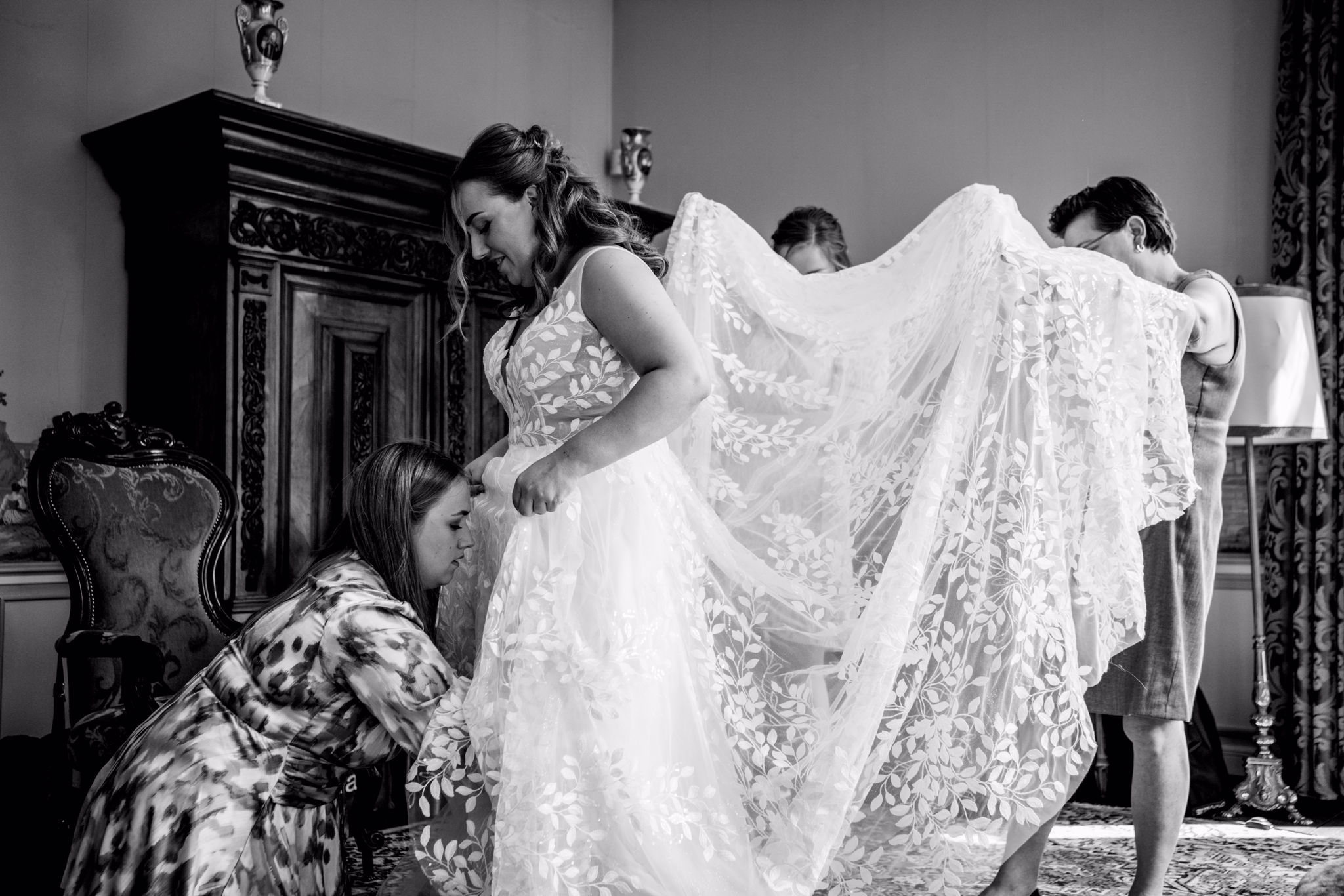 Bruid trekt trouwjurk aan met hulp familie vrienden